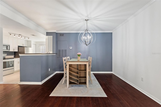 dining space featuring ornamental molding, light wood-style flooring, and baseboards