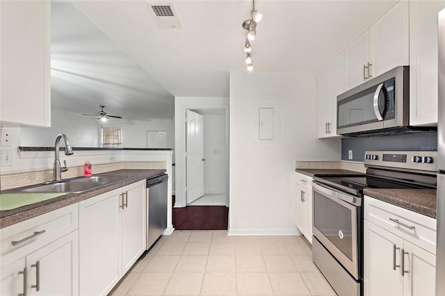 kitchen featuring dark countertops, visible vents, stainless steel appliances, and a sink