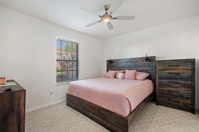 bedroom featuring baseboards, ceiling fan, and light colored carpet