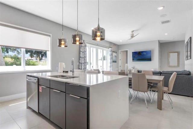 kitchen featuring a center island with sink, visible vents, a sink, stainless steel dishwasher, and open floor plan