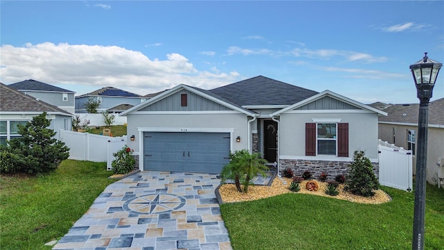 view of front of house with driveway, a front lawn, a gate, stone siding, and fence