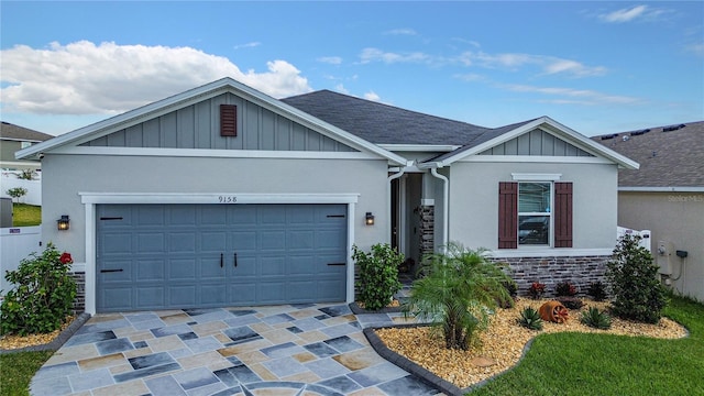 single story home featuring board and batten siding, roof with shingles, decorative driveway, a garage, and stone siding