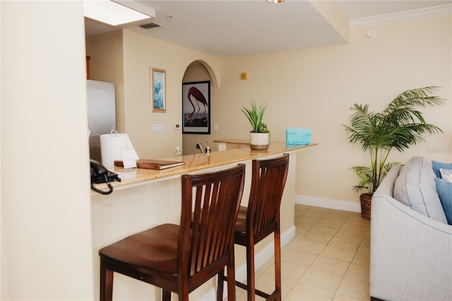 bar with visible vents, baseboards, light tile patterned flooring, and crown molding