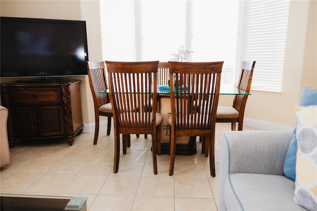 dining area featuring light tile patterned floors, baseboards, and plenty of natural light