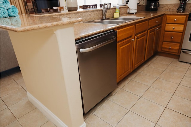 kitchen featuring stainless steel dishwasher, light tile patterned flooring, brown cabinetry, and a sink