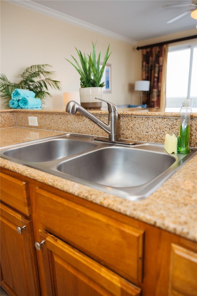 room details featuring a sink, brown cabinets, crown molding, and light countertops