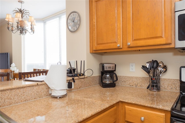 kitchen with a wealth of natural light, a notable chandelier, and white microwave