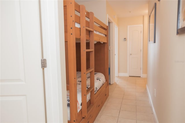 hallway with light tile patterned floors and baseboards