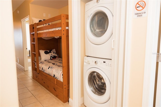 laundry room featuring tile patterned floors, stacked washer / drying machine, and laundry area