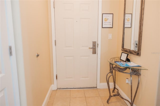 doorway to outside featuring light tile patterned floors and baseboards