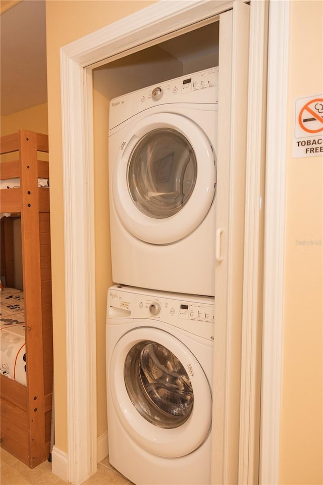 clothes washing area with laundry area and stacked washing maching and dryer