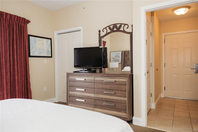 bedroom featuring light tile patterned floors and baseboards