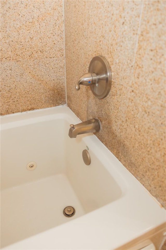 interior details with a tub and walk in shower