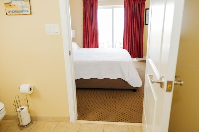 bedroom featuring tile patterned floors and baseboards