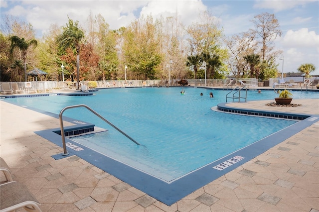 community pool featuring a patio and fence