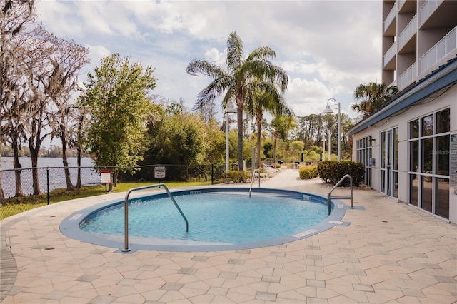 pool with a patio area and fence