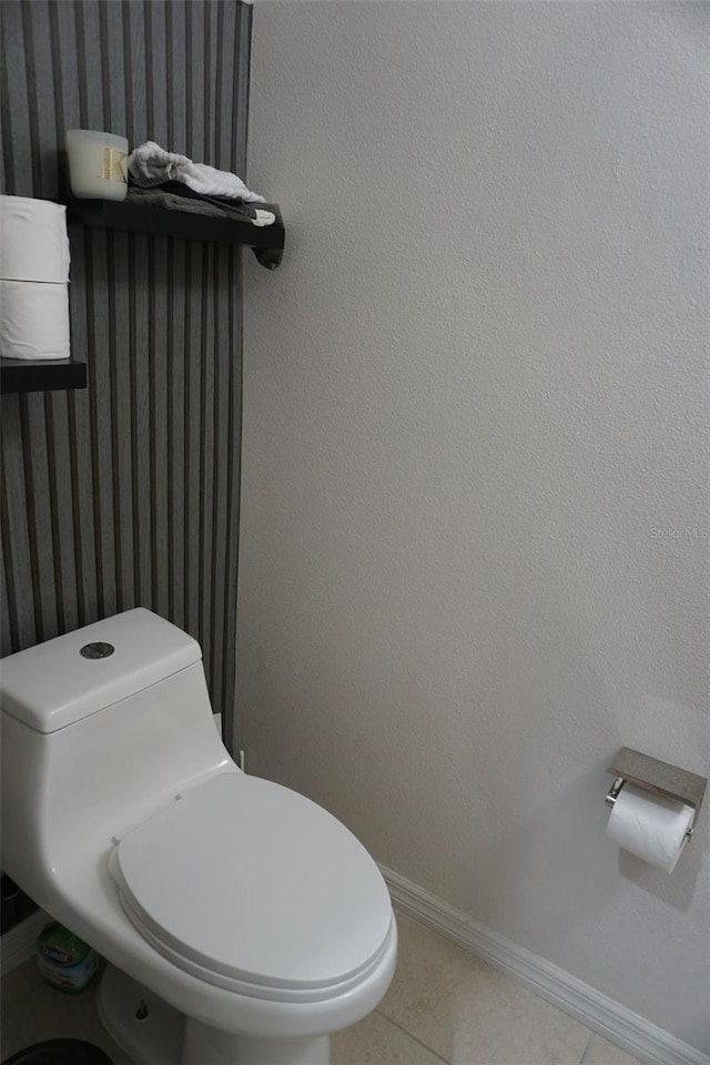 bathroom with baseboards, toilet, and tile patterned floors