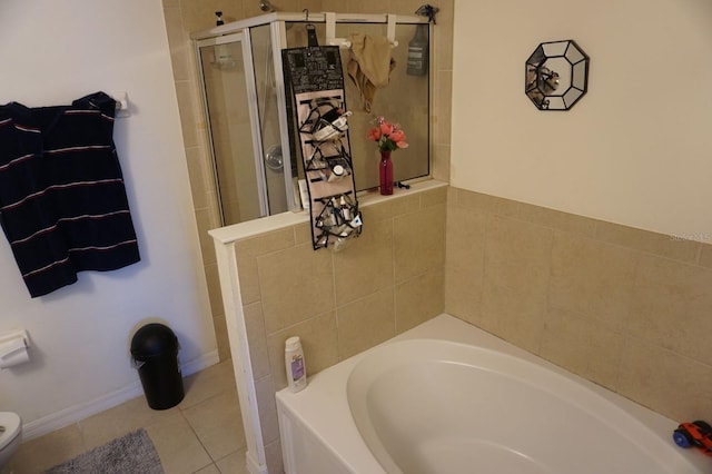 bathroom with a bath, a shower stall, toilet, and tile patterned flooring