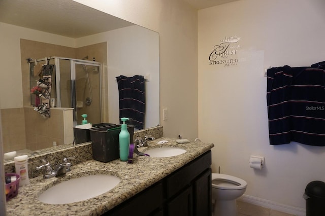 full bath featuring a stall shower, a sink, toilet, and double vanity