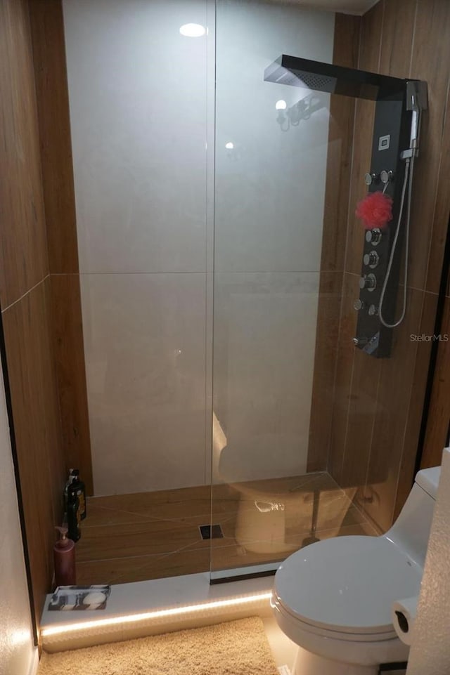 full bath with toilet and a shower stall