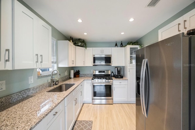 kitchen featuring white cabinets, stainless steel appliances, and a sink