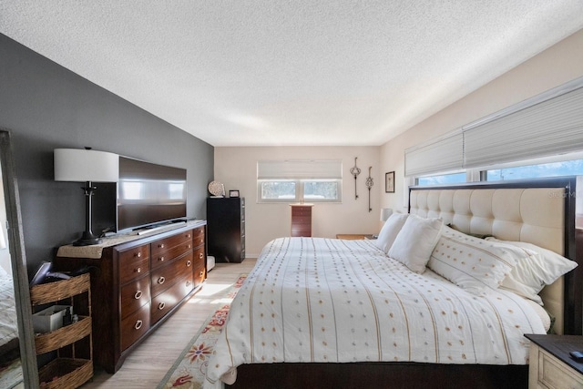 bedroom with light wood-style flooring and a textured ceiling