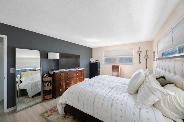 bedroom with light wood-style flooring and a textured ceiling