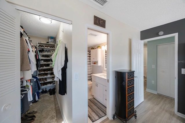 walk in closet with light wood-style floors and visible vents