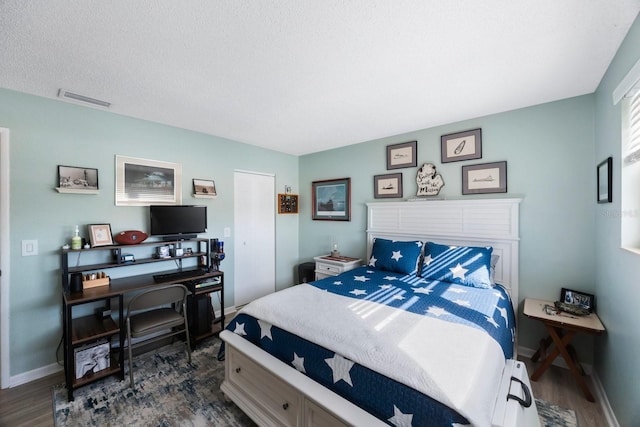 bedroom with dark wood-type flooring, visible vents, and baseboards