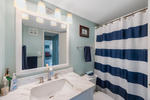 full bath with visible vents, toilet, vanity, and a shower with curtain