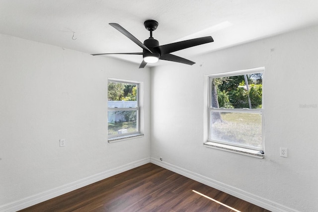 unfurnished room with baseboards, dark wood finished floors, and a ceiling fan