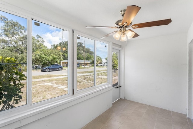 unfurnished sunroom featuring a ceiling fan