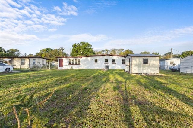 exterior space with a storage shed, an outbuilding, a yard, and fence