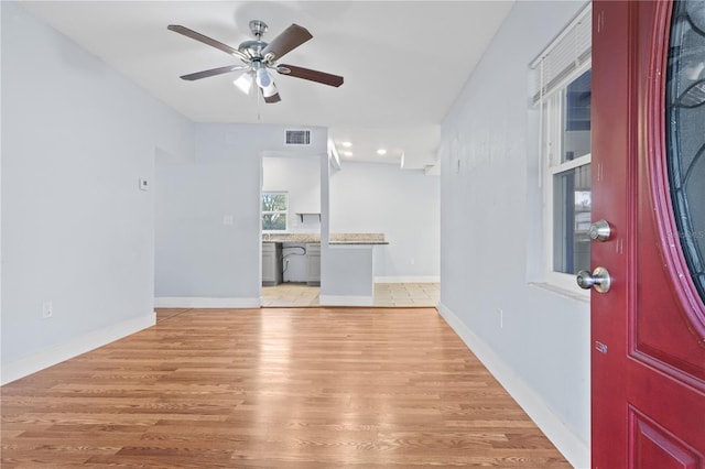 entryway with visible vents, baseboards, ceiling fan, and light wood finished floors