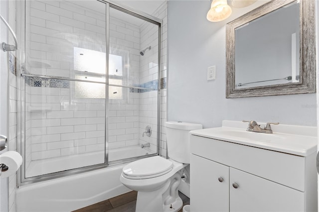 full bath with vanity, toilet, wood finished floors, and combined bath / shower with glass door