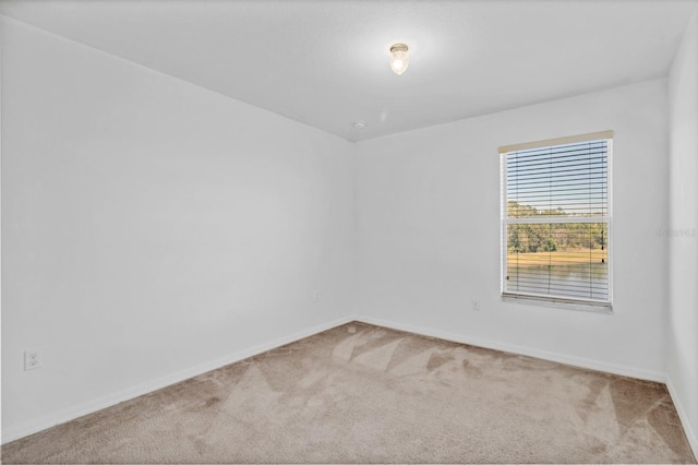 empty room with carpet and baseboards