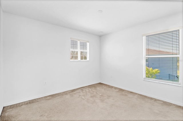 carpeted spare room with baseboards