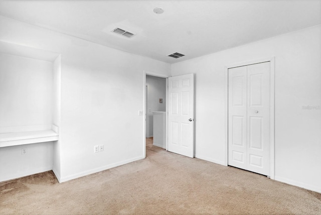 unfurnished bedroom featuring carpet, visible vents, and baseboards