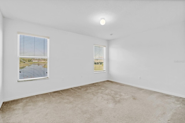 carpeted spare room with baseboards