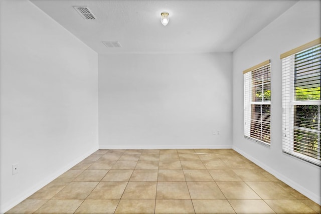 spare room with light tile patterned floors, baseboards, and visible vents