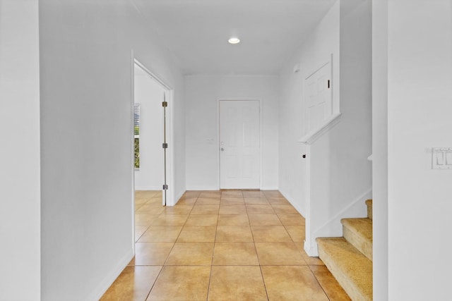 hall featuring light tile patterned floors, baseboards, stairway, and recessed lighting