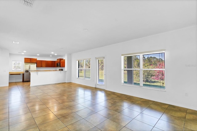 unfurnished living room with light tile patterned floors, visible vents, and recessed lighting