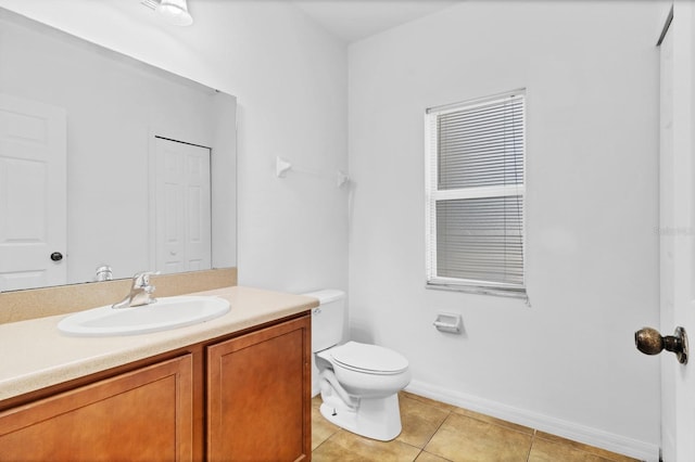 bathroom featuring tile patterned flooring, baseboards, vanity, and toilet