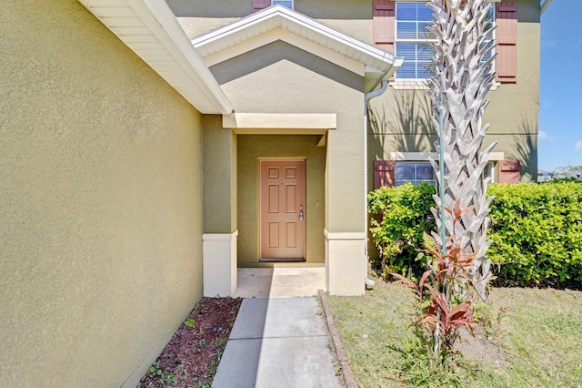 entrance to property featuring stucco siding