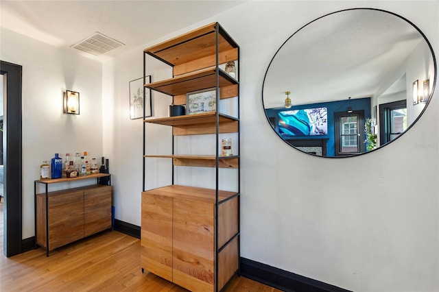 room details with baseboards, visible vents, and wood finished floors