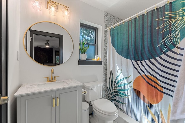 bathroom with toilet, curtained shower, and vanity