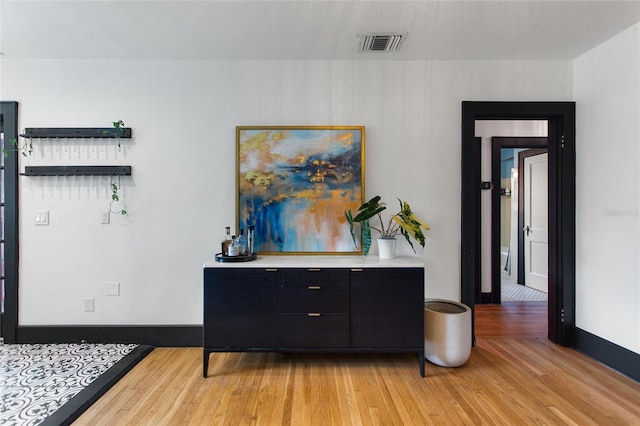 interior space featuring light wood-style floors, visible vents, and baseboards