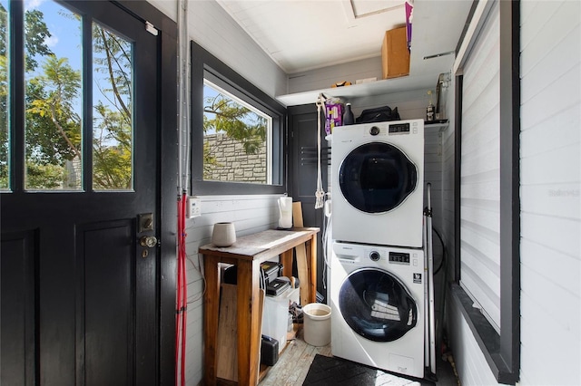 washroom featuring laundry area, stacked washer / dryer, and wood finished floors