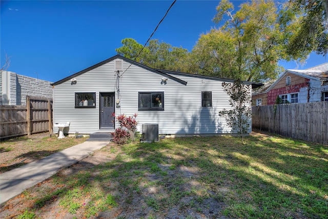 exterior space with entry steps, a fenced backyard, cooling unit, and a yard