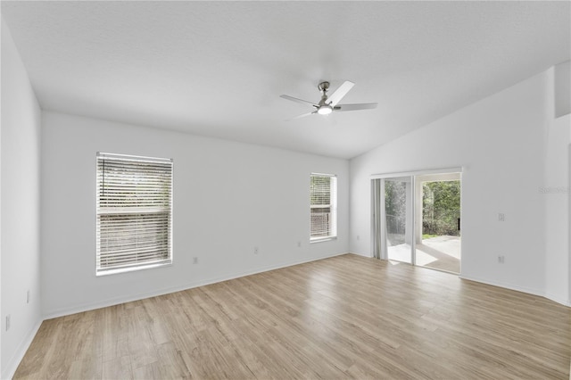 spare room featuring lofted ceiling, ceiling fan, baseboards, and light wood-style floors